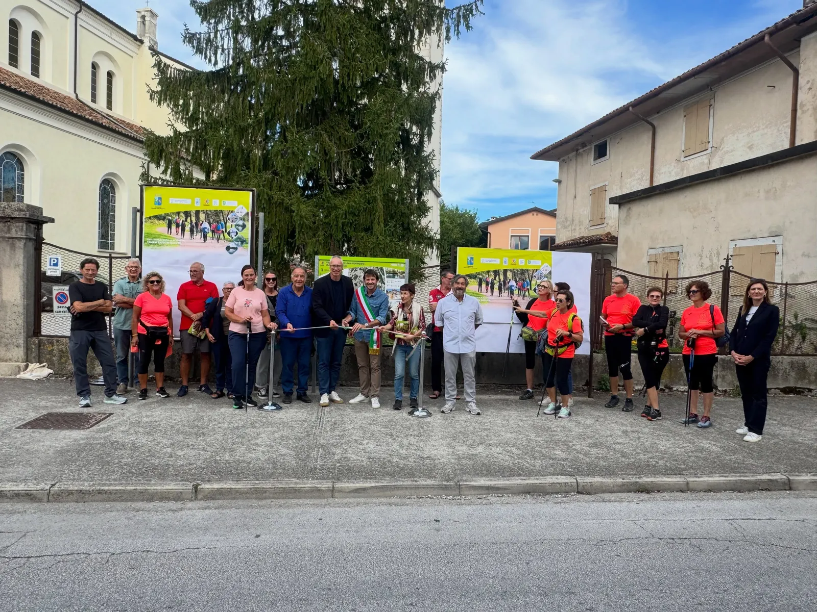 Participants at the ribbon cutting, in front of the route information boards.
