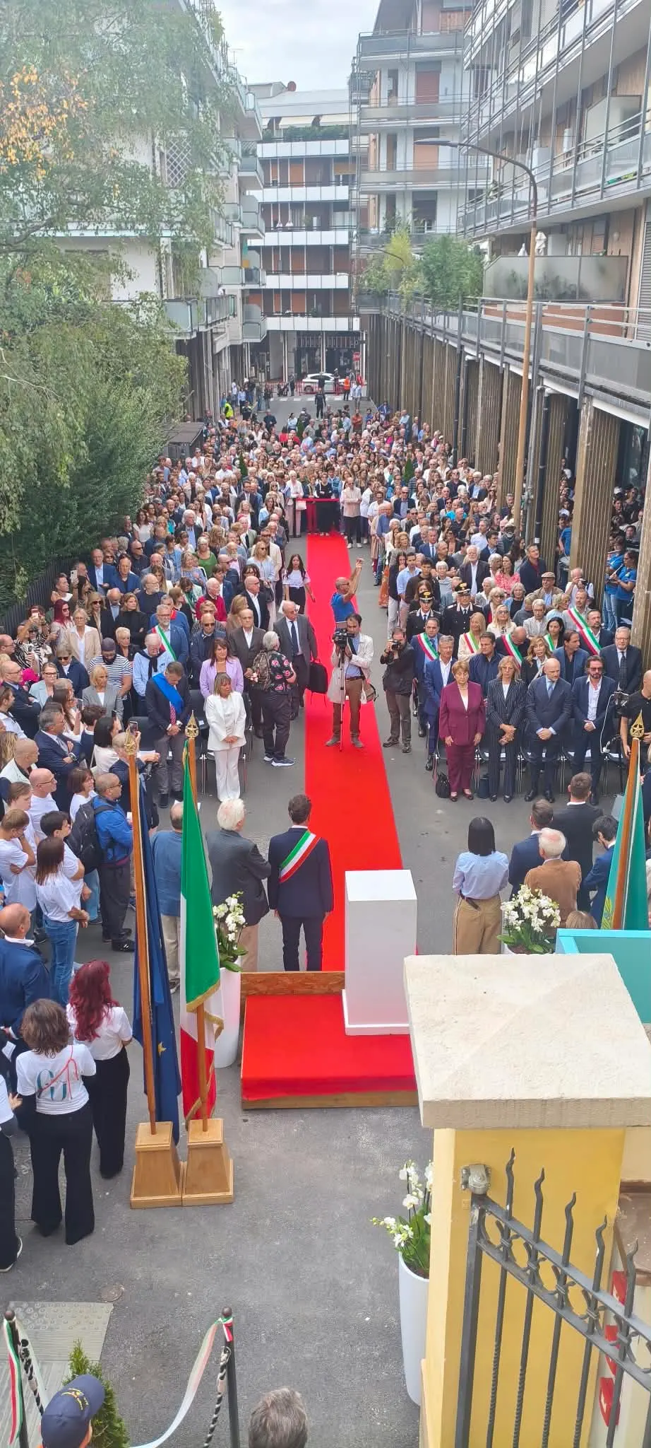People gathered for the Fanny Usellini Museum opening beside a red carpet in the courtyard.