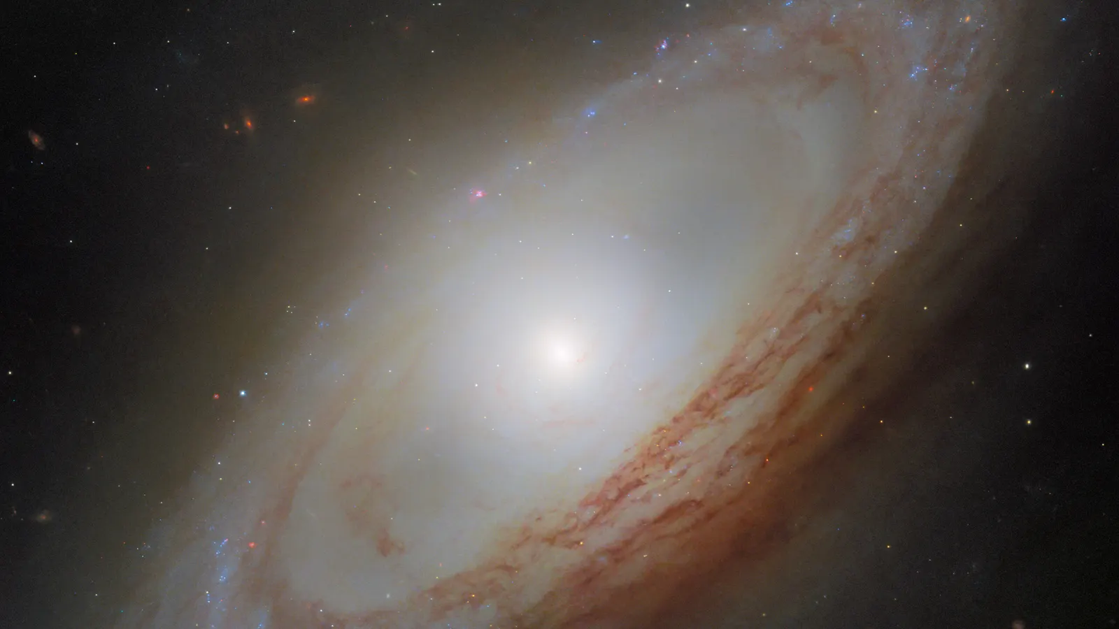 Galaxy NGC 4698 with a bright centre, spiral arms and dust lanes against a dark background.
