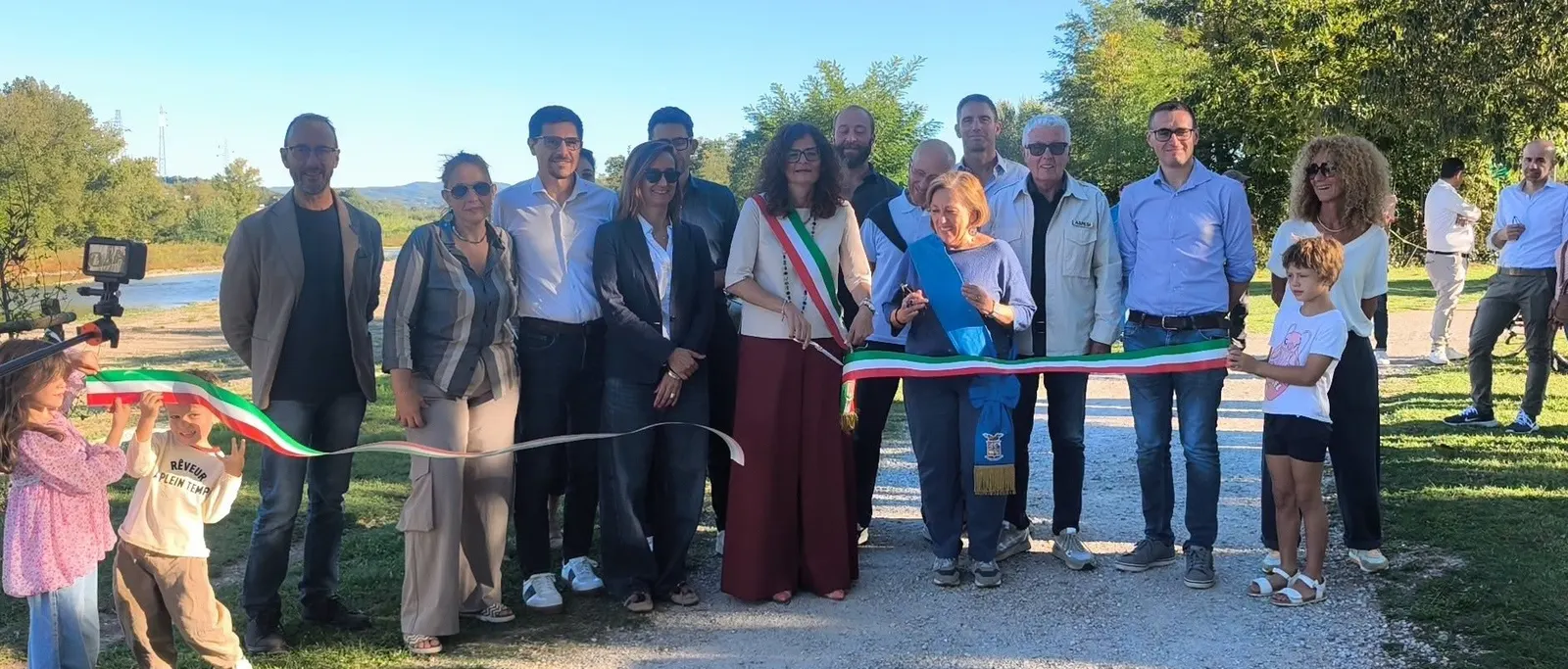 A group beside a tricolour ribbon at the presentation of the Arno riverbank works.
