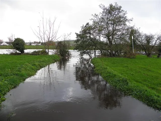 High water on the River Derg among grassy banks and trees at Castlederg, photographed in 2010.