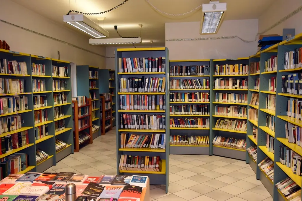 Bookcases with yellow edges and a table inside San Polo library.