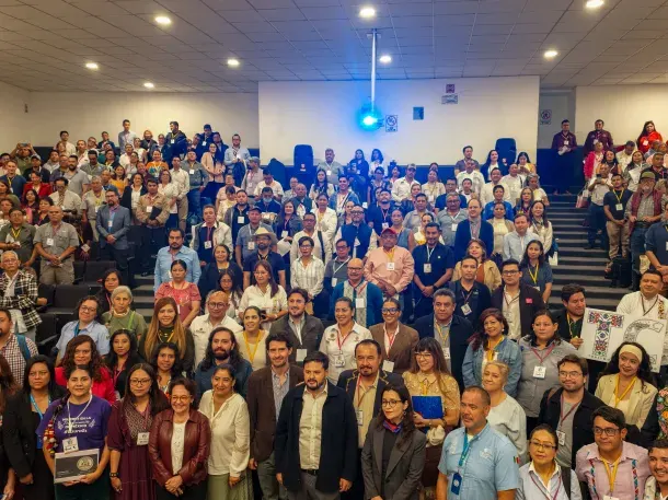 Participants in the community tourism forum pose together in a university lecture hall.