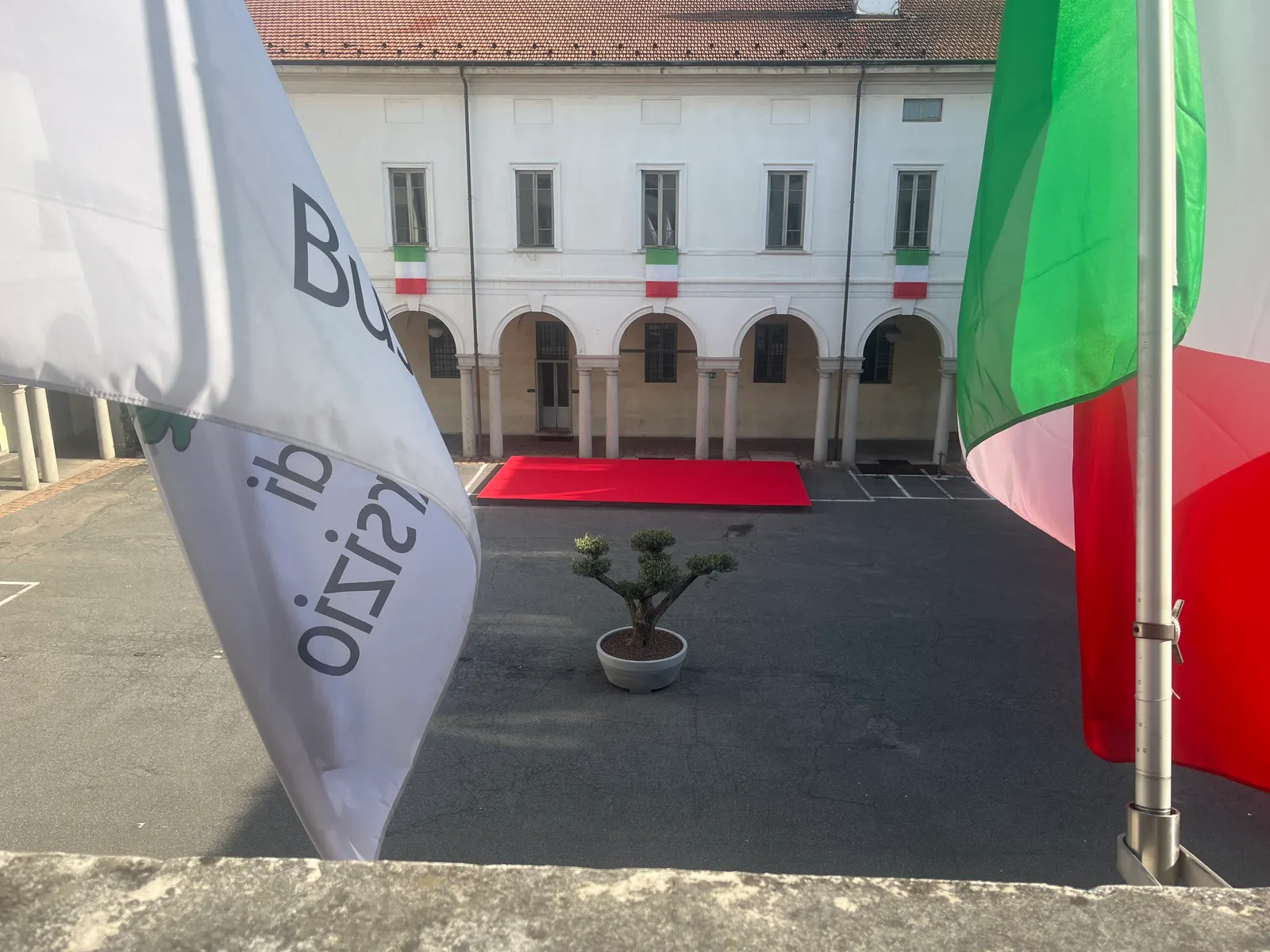 The courtyard of Busto Arsizio’s town hall with institutional flags.