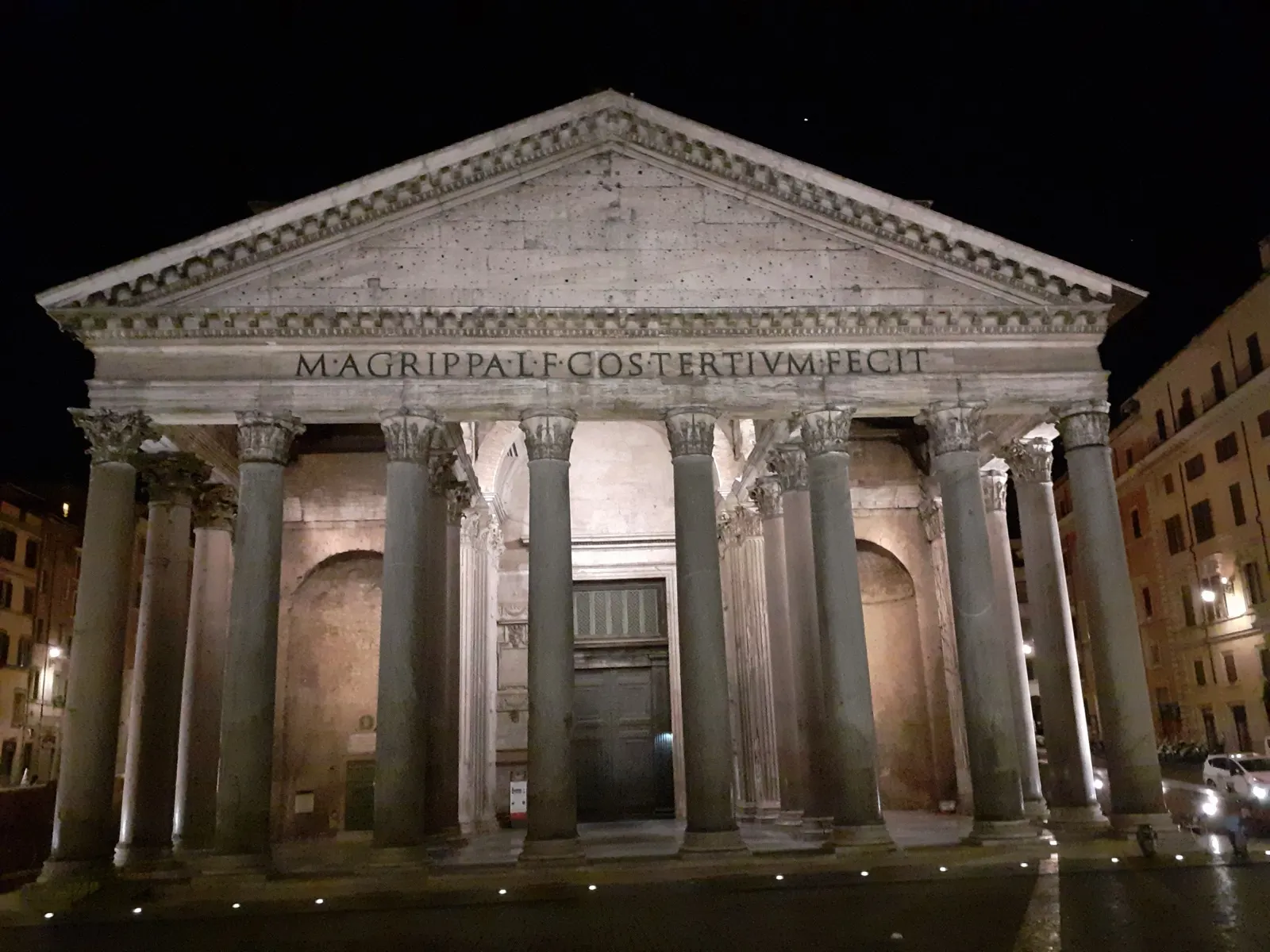 The pediment and columns of the Pantheon illuminated at night in Rome.
